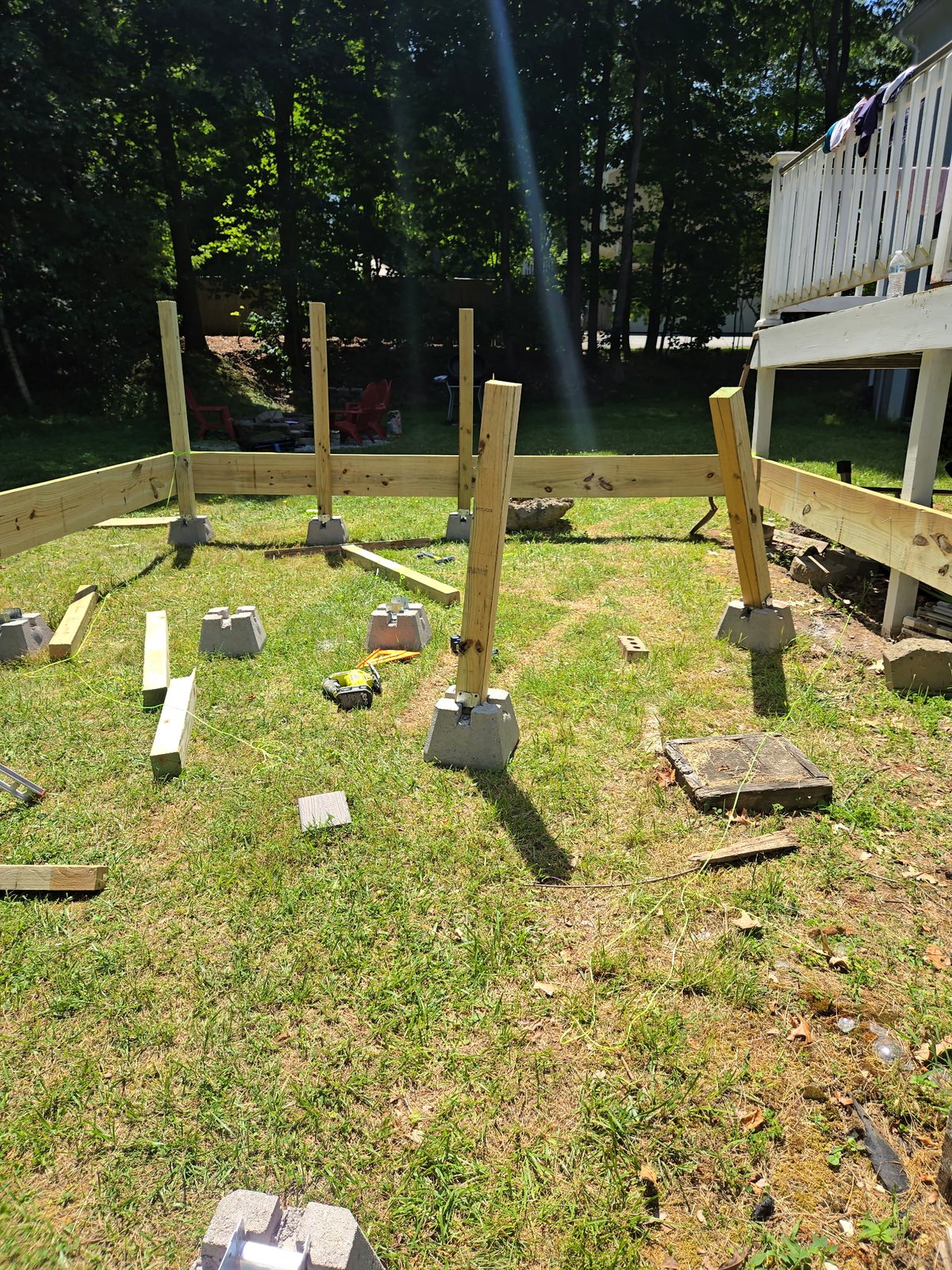 Deck post layout with concrete footings and pressure-treated framing in a Rhode Island backyard