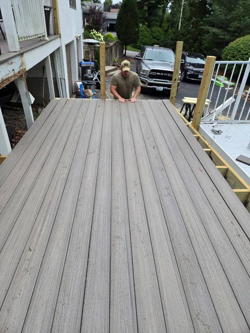 Composite deck boards being installed over repaired framing