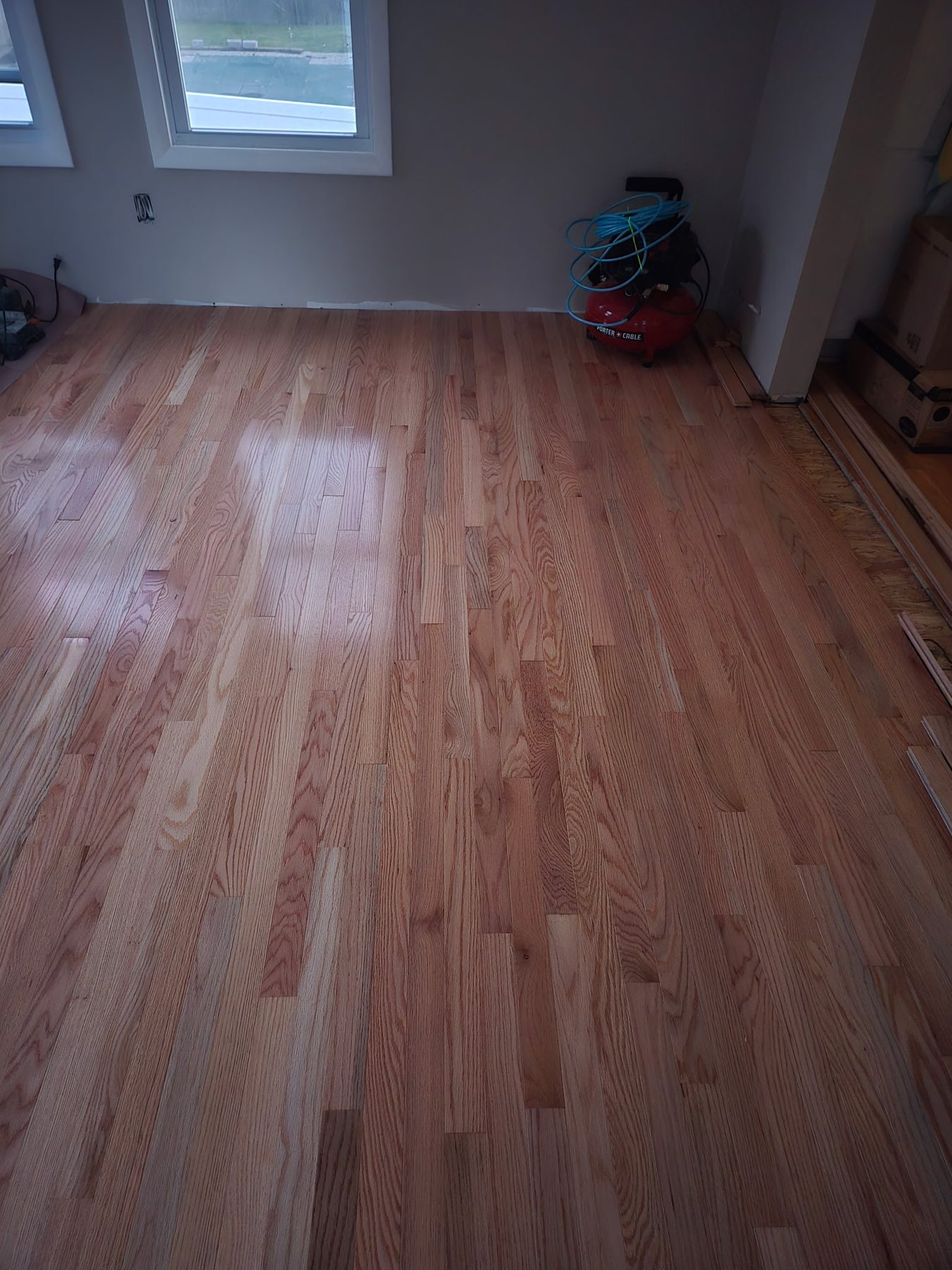 Refinished hardwood floor near a bay window in Rhode Island