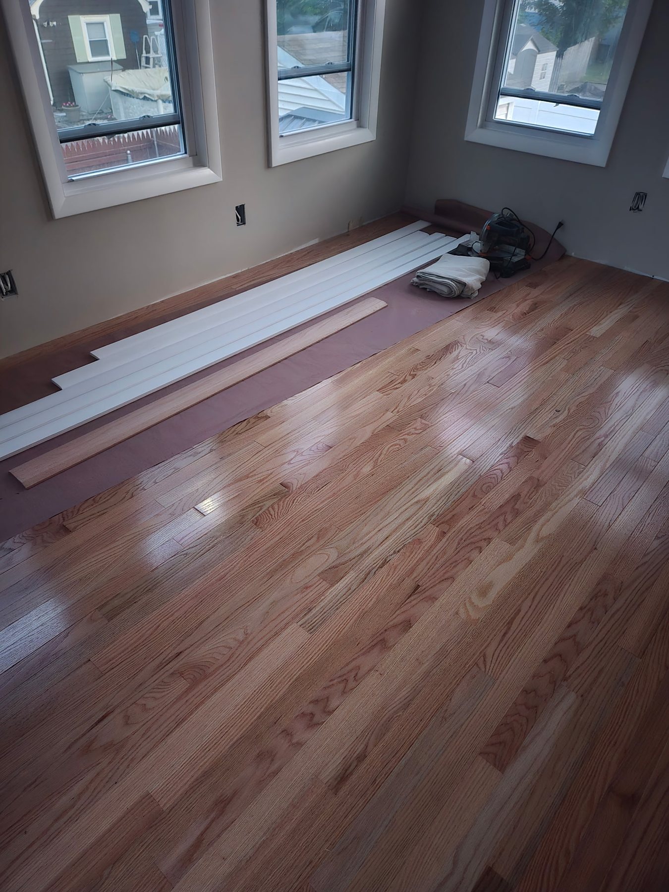 Natural hardwood flooring with a clean reflective finish in a bright Rhode Island bedroom